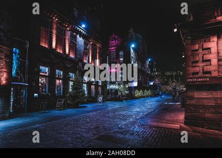 Édimbourg, Écosse, 13 décembre 2018 : Les gens qui marchent le long de Victoria St. et Ramsay Lane, de nuit entouré de bâtiments lumineux colorés avec Banque D'Images