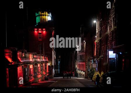 Édimbourg, Écosse, 13 décembre 2018 : rassemblement de personnes en cercle au milieu de la rue Victoria la nuit entouré de bâtiments lumineux colorés Banque D'Images