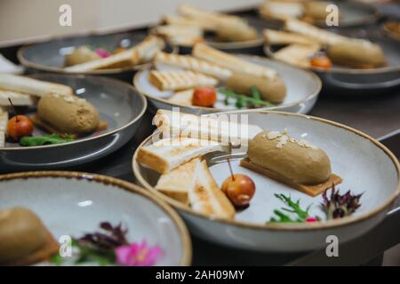 Pate maison est servi avec des tranches de pain frit. La nourriture est sur une plaque ronde, blanche, prêt à être servi. Banque D'Images