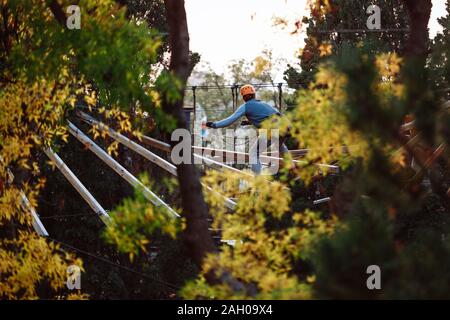 Climber dans l'équipement des trains pour marcher sur les barres de bois pure. Banque D'Images