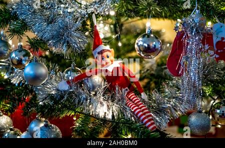 Selective focus on naughty lutin de Noël assis dans un arbre de Noël décoré Banque D'Images