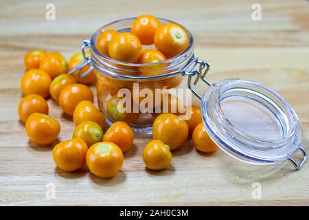 Physalis en coupe du verre sur table en bois Banque D'Images