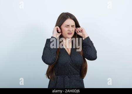 Déçu femme gardant le doigt sur les oreilles, serrant face Banque D'Images