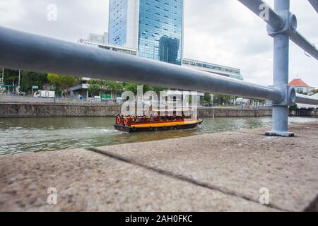 Bateau touristique bum c'est rempli de touristes de l'Inde et d'autres pays les gens à profiter de l'expérience et la vue sur la ville le long de la rivière Singapour. Banque D'Images