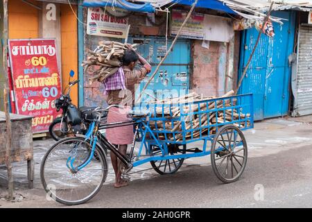 Vue arrière de l'homme transporter le bois sur son épaule, Trichy, Tamil Nadu, Inde Banque D'Images