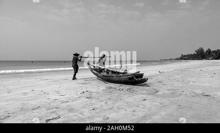 Deux pêcheurs locaux qui arrivent à terre les eaux chaudes de la baie du Bengale. La plage de Ngapali, à l'État de Rakhine, au Myanmar Banque D'Images