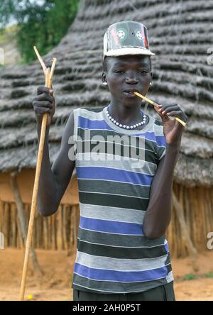 Larim tribu garçon avec un fashionnable look en utilisant une brosse à dents en bois, Boya, montagnes Imatong, au Soudan du Sud Banque D'Images