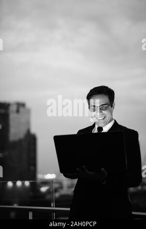 Handsome businessman Perse contre l'avis de la ville la nuit Banque D'Images