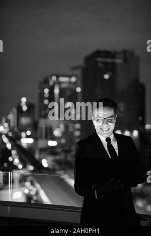 Handsome businessman Perse contre l'avis de la ville la nuit Banque D'Images