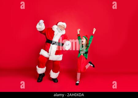 Corps plein de photos du père noël excité dans elf hat casquettes avec redhead white coupe de lever les poings crier oui célébrer partie porter costume vert Banque D'Images