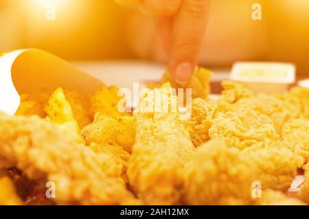 Close up une fille de manger des frites et des nuggets de poulet doré. Banque D'Images