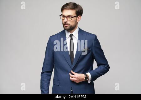 Portrait d'un beau jeune homme élégant, portant des lunettes sur fond gris Banque D'Images