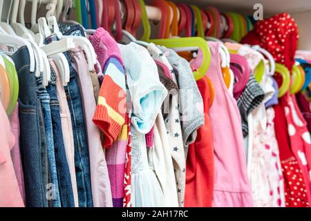 Grand choix de couleurs, les vêtements pour enfants pour une fille pendu dans un placard, sur des cintres. Banque D'Images