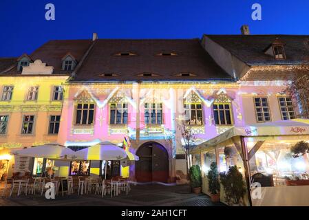 Illuminations de Noël sur les magnifiques bâtiments médiévaux dans Piata Mare, dans la région de Sibiu, en Transylvanie, Roumanie Banque D'Images