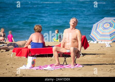 Les touristes bronzer sur la plage de la ville de Las Palmas sur Gran Canaria. Une destination populaire de soleil d'hiver pour beaucoup de Brits. Banque D'Images