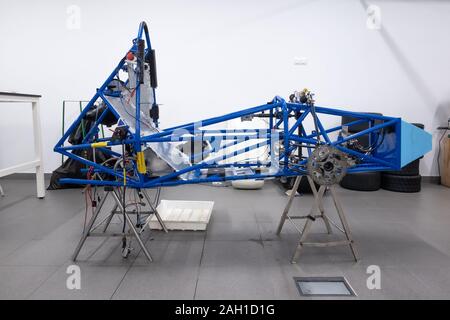 Voiture sur mesure en cours de construction en atelier. Corps de voiture de sport, location de cadre assemblé par la mécanique. Châssis auto métallique dans l'air, location de squelette en service Banque D'Images