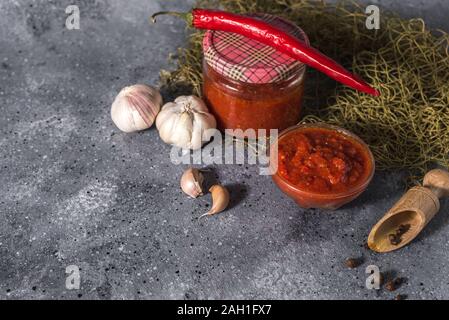 Cuisine mexicaine traditionnelle, géorgienne et la pâte de piment harissa arabe sur un fond de béton gris. La nourriture épicée utiles Banque D'Images