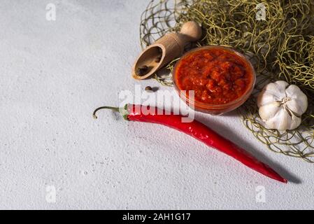 Cuisine mexicaine traditionnelle, géorgienne et la pâte de piment harissa arabe sur un fond de béton gris. La nourriture épicée utiles Banque D'Images