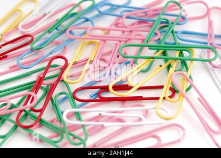 Close-up of multi-colored trombones sur un fond blanc. Banque D'Images
