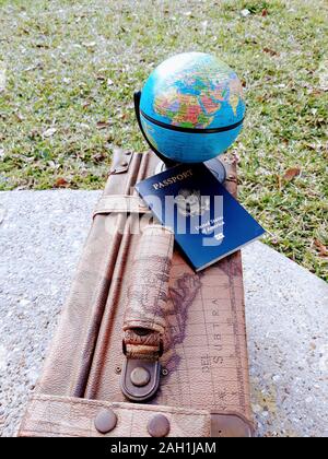 Vintage Voyage valise en cuir à thème avec un globe et passeport Banque D'Images