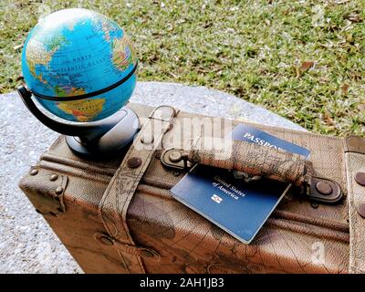 Vintage Voyage valise en cuir à thème avec un globe et passeport Banque D'Images