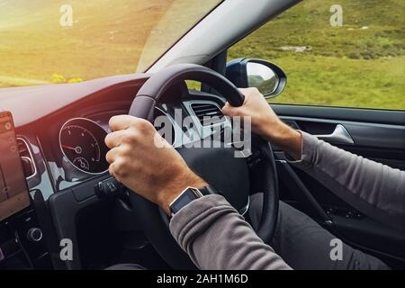 L'Homme conduisant la voiture de droite. Close-up shot of man's hands holding volant. Les voyages, la location d'une voiture à l'étranger. Banque D'Images