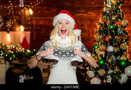 Hiver actif. Femme Santa hat avec des patins. Cheerful girl avec paire de patins. Cadeau de Noël du patineur. Plaisir d'hiver les vacances de Noël. Sports d'hiver. Idées pour les loisirs. L'équipement sport de plein air. Banque D'Images