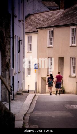 Un jeune couple en train de marcher dans les rues étroites Fowet de Cornwall. Banque D'Images