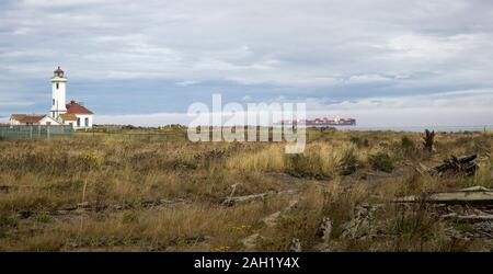 Porte-conteneurs passant le Point Wilson Phare près de Port Townsend, Washington, United States Banque D'Images