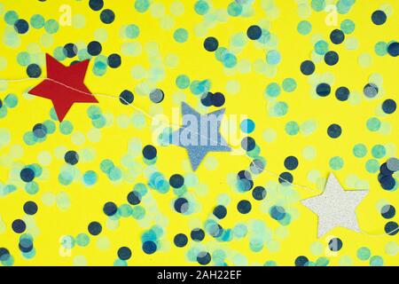 La guirlande d'étoiles colorées et confettis blancs sur fond jaune classique. Banque D'Images