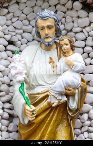 La statue de Saint Joseph tenant l'Enfant Jésus dans ses bras près du sanctuaire de Notre Dame de Tylicz. Banque D'Images