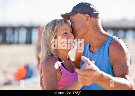 Man kissing a young woman sur la joue. Banque D'Images