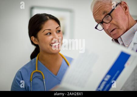 Médecin Senior consulting avec une jeune infirmière. Banque D'Images
