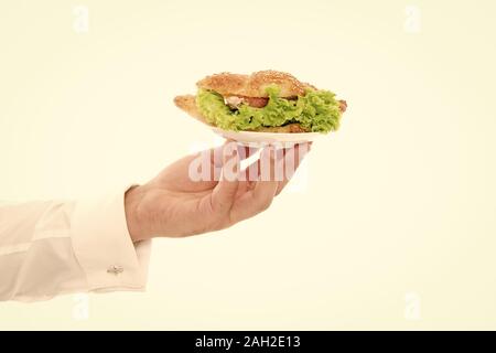 Les Calories et les régimes amaigrissants. Main de garçon porter la plaque avec le plat. De délicieux croissants. Servant un croissant farci de laitues et légumes frais. Cafe concept. Alimentation saine. Croissant traditionnel français. Banque D'Images