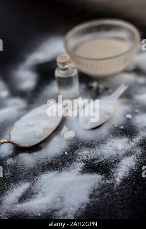 Masque de visage ou masque de bicarbonate de soude dans un bol en verre sur la surface en bois avec un peu de noix de coco en poudre et l'huile dans un flacon en verre transparent. Utilisé pour Banque D'Images