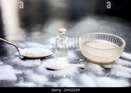 Masque de visage ou masque de bicarbonate de soude dans un bol en verre sur la surface en bois avec un peu de noix de coco en poudre et l'huile dans un flacon en verre transparent. Utilisé pour Banque D'Images