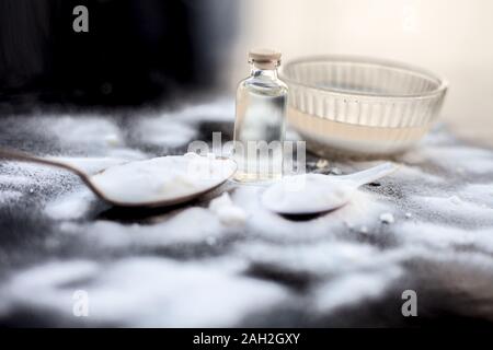 Masque de visage ou masque de bicarbonate de soude dans un bol en verre sur la surface en bois avec un peu de noix de coco en poudre et l'huile dans un flacon en verre transparent. Utilisé pour Banque D'Images
