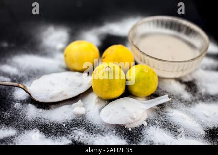 Masque de bicarbonate de soude dans un bol en verre sur la surface en bois avec certaines bicarbonate de soude saupoudré sur la surface et les citrons aussi sur la surface. Utilisé pour blemi Banque D'Images