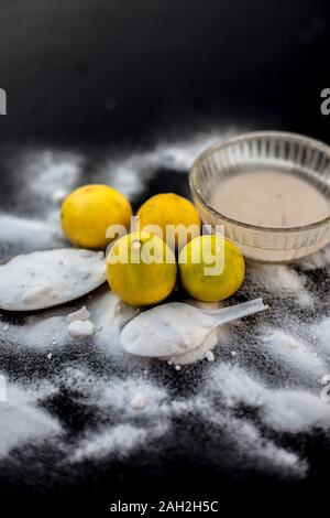 Masque de bicarbonate de soude dans un bol en verre sur la surface en bois avec certaines bicarbonate de soude saupoudré sur la surface et les citrons aussi sur la surface. Utilisé pour blemi Banque D'Images