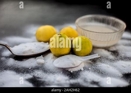 Masque de bicarbonate de soude dans un bol en verre sur la surface en bois avec certaines bicarbonate de soude saupoudré sur la surface et les citrons aussi sur la surface. Utilisé pour blemi Banque D'Images