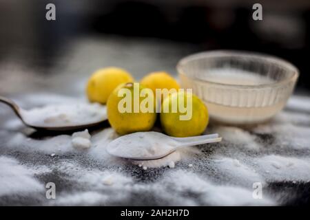 Masque de bicarbonate de soude dans un bol en verre sur la surface en bois avec certaines bicarbonate de soude saupoudré sur la surface et les citrons aussi sur la surface. Utilisé pour blemi Banque D'Images