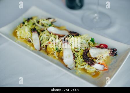 Octopus carbonisé avec des légumes et de la salade au restaurant Banque D'Images