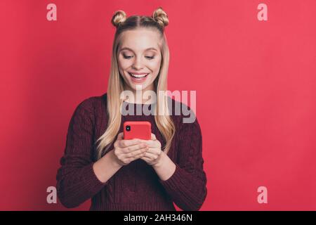 Photo d'influenceur incroyable dame holding téléphone dans les mains de la lecture des commentaires positifs dans blog porter des étoffes de couleur rouge pastel isolés de cavalier Banque D'Images