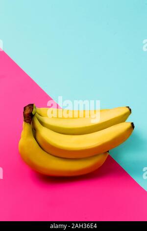 Gros plan du cluster de la banane sur fond bleu et rose Banque D'Images