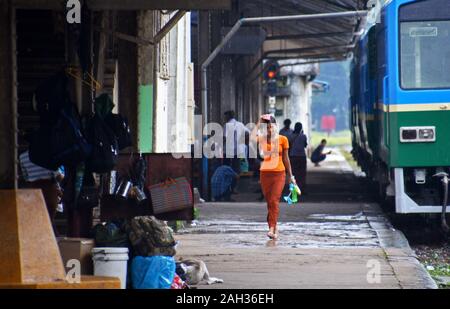 Une femme marche le long de la plate-forme de la gare centrale de Yangon, Birmanie Banque D'Images