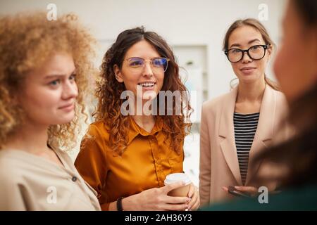 Groupe de quatre cheerful young women chatting pendant les pauses, horizontal tourné Banque D'Images
