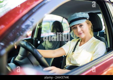 Vue latérale d'une jeune femme heureuse Driving Car Banque D'Images