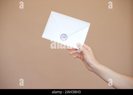 Photo en gros plan des femmes avec sceau en cire avec enveloppe d'invitation, certificat-cadeau, carte postale, carte d'invitation de mariage. Banque D'Images