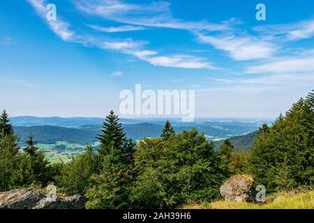 Vue du haut d'une montagne dans la vallée de nuages sur le ciel et les montagnes de l'arrière-plan et les pierres et les arbres en face de l'avant en Bavière Banque D'Images