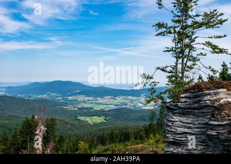 Vue du haut d'une montagne dans la vallée de nuages sur le ciel et les montagnes de l'arrière-plan et les pierres et les arbres en face de l'avant en Bavière Banque D'Images